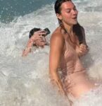 Irmã de Shawn Mendes é batizada em praia no RJ e leva caldo ao lado do cantor